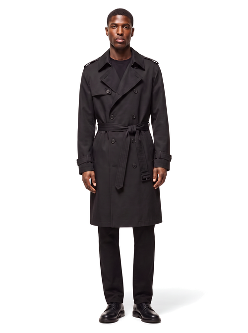Black double breasted belted trench coat worn by model, front view on white