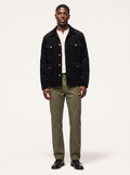 Black corduroy cargo jacket with flap pockets worn by model, front view on white