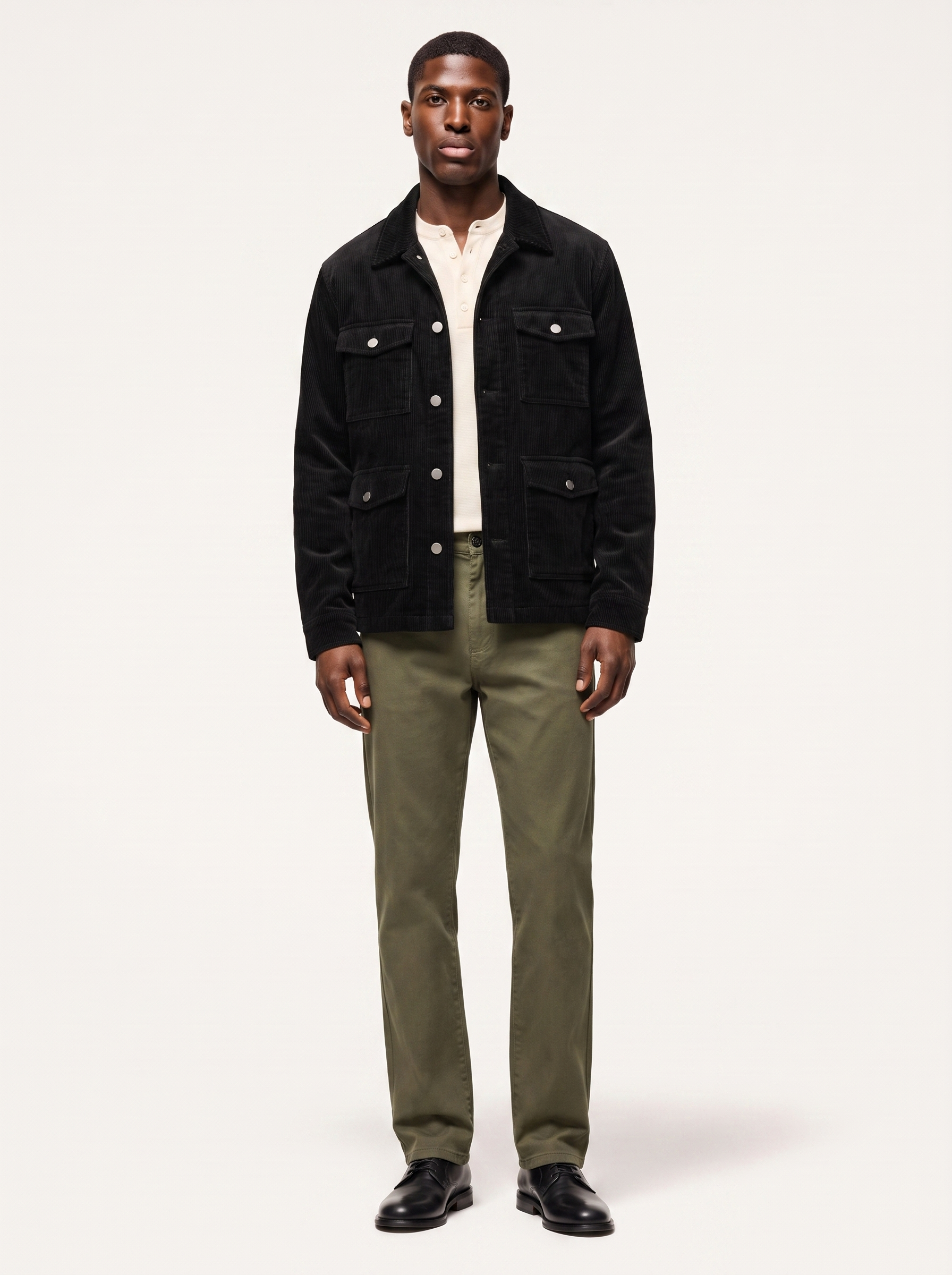Black corduroy cargo jacket with flap pockets worn by model, front view on white
