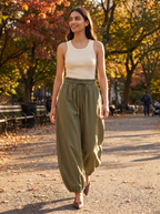 Woman wearing olive balloon pants walking in autumn park, lifestyle