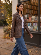 Woman wearing vintage brown faux leather blazer on city street, lifestyle