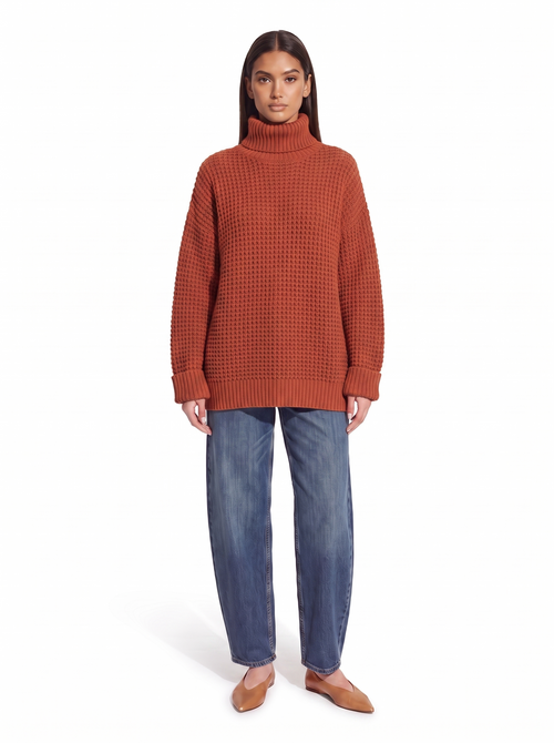 Brick red oversized honeycomb knit turtleneck worn by model, front view on white