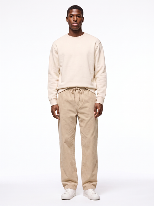 Beige wide leg corduroy pants worn by model, front view on white