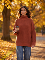Woman wearing brick red oversized turtleneck walking through autumn park, lifestyle