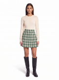 Green check pleated mini skirt worn by model, front view on white