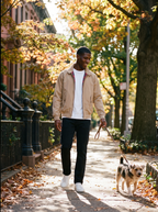 Man wearing beige harrington walking dog on fall afternoon, lifestyle