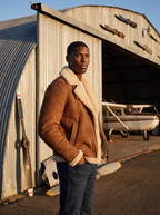 Shearling aviator jacket lifestyle at hangar golden hour