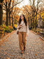 Woman wearing oatmeal button-front knit cardigan with camel trousers in autumn