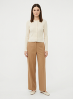 Cream ribbed knit cardigan worn by model, front view on white