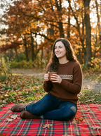 Woman wearing chestnut jacquard sweater at an autumn picnic