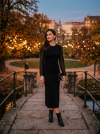 Woman wearing black sheer sleeve midi dress at dusk in autumn