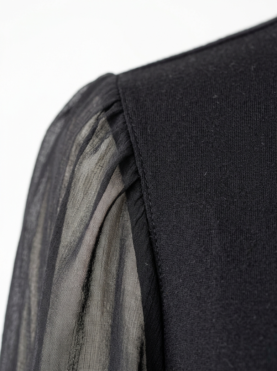 Sheer chiffon sleeve and opaque bodice seam close up detail