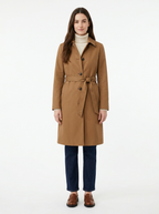 Camel trench coat worn by model, front view on white