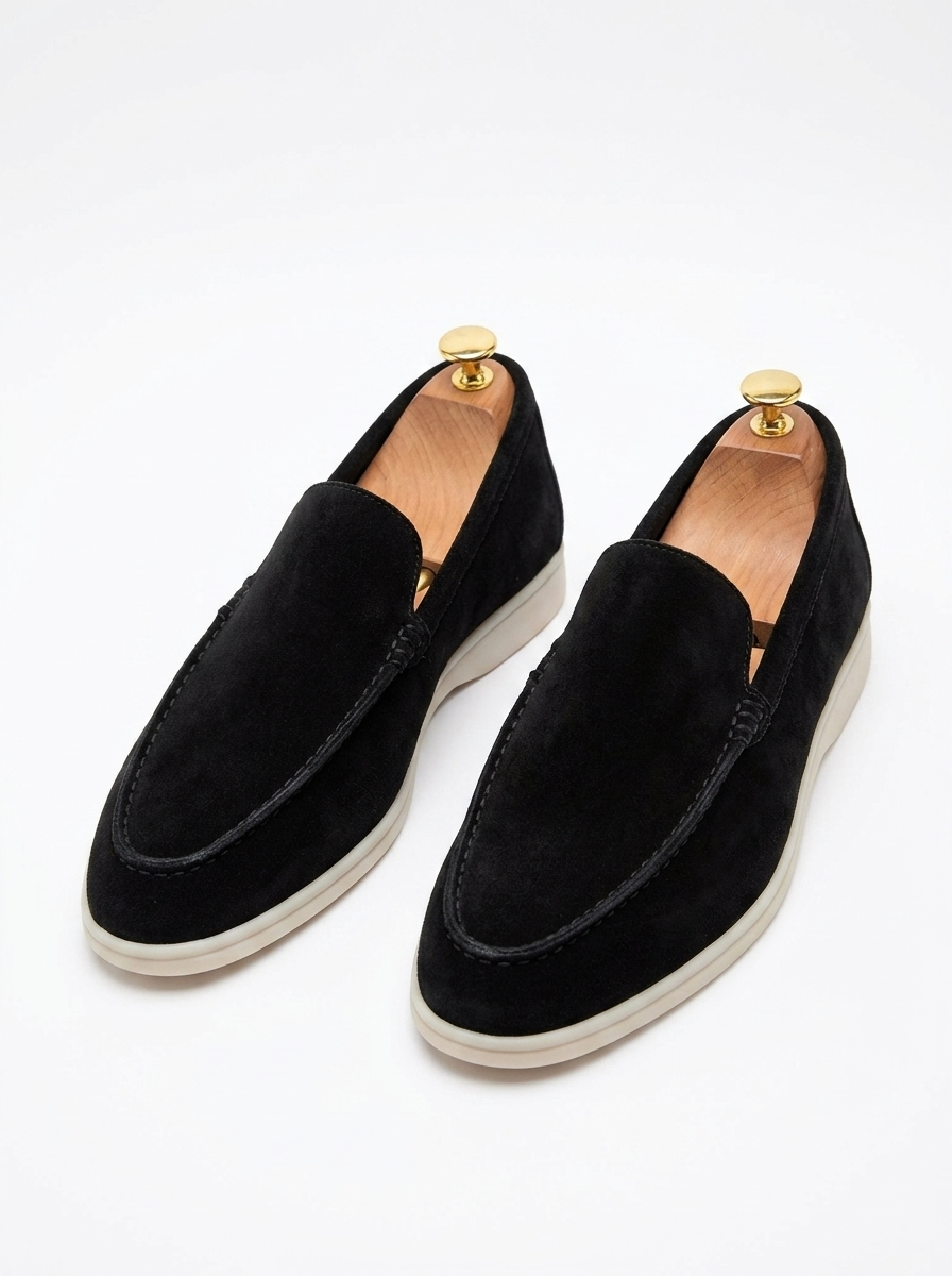 Black suede laceless slip-on loafers, pair on white